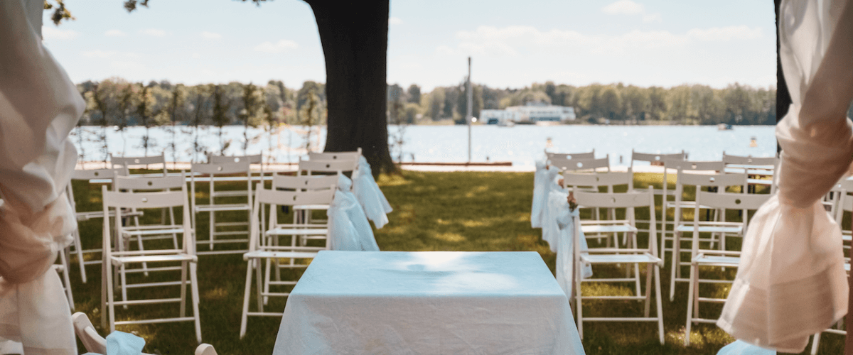 Vorbereitung Hochzeitscatering: Stühle und Tisch in weiß