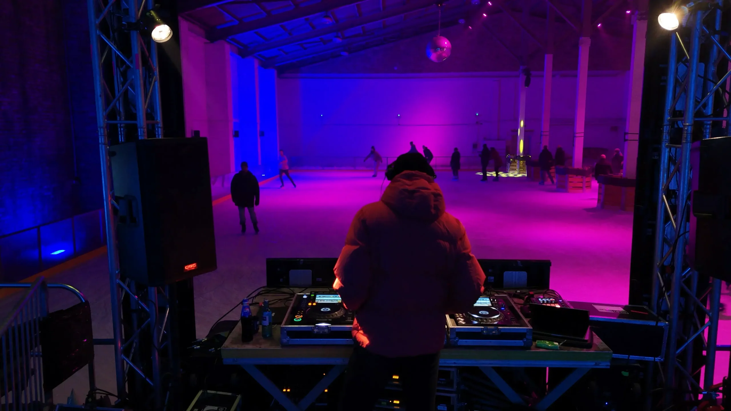Ein DJ und im Hintergrund die Indoor-Eisbahn.